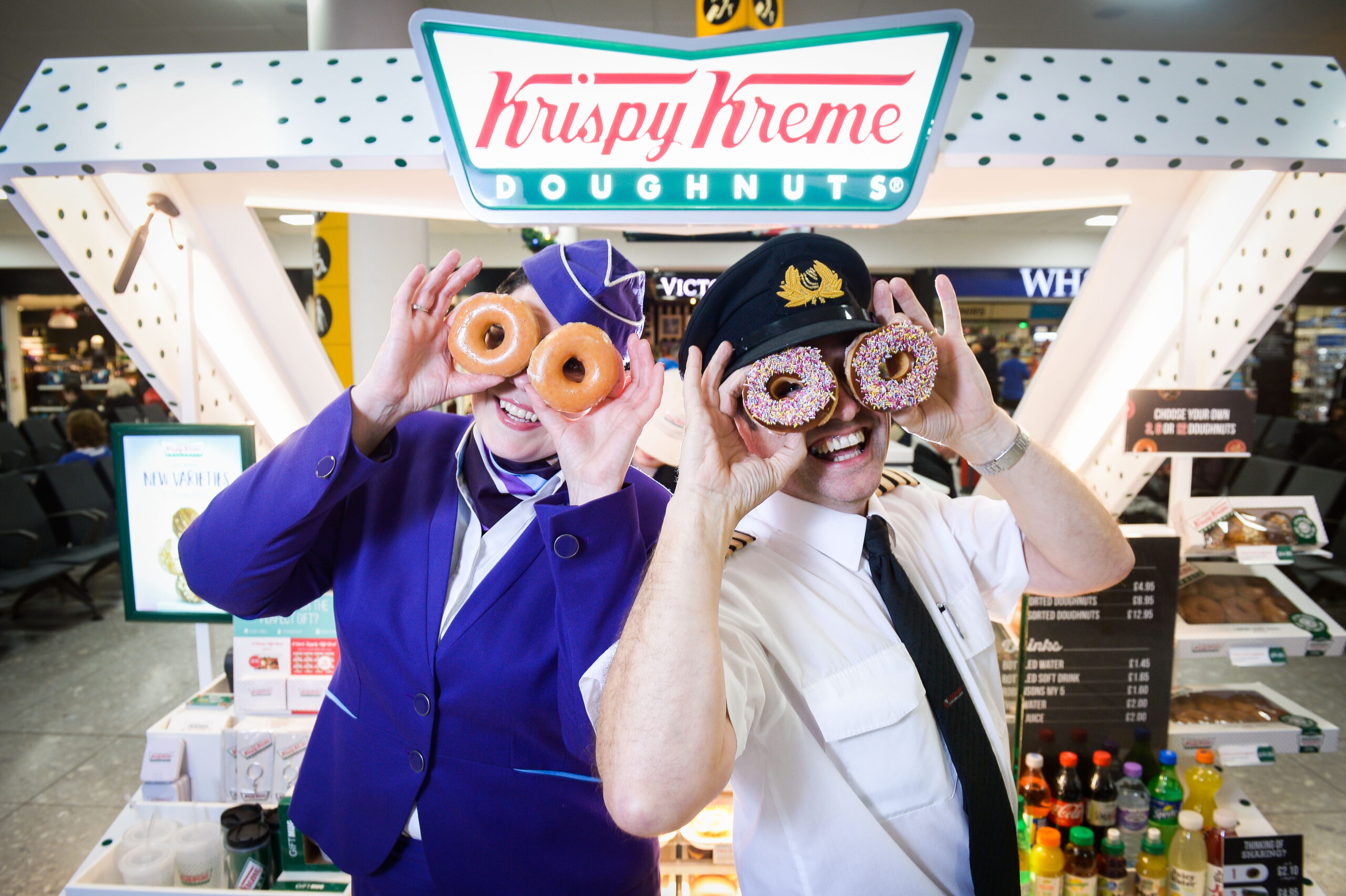 Picture by Nick Ponty 19/11/16 Krispy Kreme opens at Glasgow Airport Logan Air Cabin Crew manager Avril McEwan and Pilot Eddie Watt try out some doughnuts.